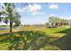 Scenic golf course view with lush green grass, palm trees, and a tranquil lake under a beautiful blue sky with clouds at 7232 Cedar Hollow Cir # 7232, Bradenton, FL 34203