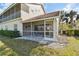 Back of home featuring a screened-in porch with table and chairs and a lush green lawn at 7232 Cedar Hollow Cir # 7232, Bradenton, FL 34203