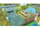 Aerial view showcasing multiple tennis courts with lush landscaping and a clubhouse at 7303 Westminster Ct, University Park, FL 34201