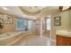 A luxurious bathroom features a soaking tub, glass block partition, and elegant finishes at 7303 Westminster Ct, University Park, FL 34201