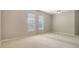 Spacious bedroom with neutral tones, carpet floors, ceiling fan, and bright natural light from large windows and mirrored wall at 7303 Westminster Ct, University Park, FL 34201