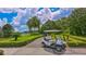 Golf cart on a path with beautiful landscaping, green lawns, and view of the lake at 7303 Westminster Ct, University Park, FL 34201