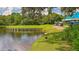 Scenic golf course view showcasing lush greenery, a serene lake, and a golf cart path under a blue sky at 7303 Westminster Ct, University Park, FL 34201