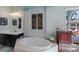 Bathroom featuring a tub, double vanity, natural light, and elegant decor at 7608 Teal Trce, Bradenton, FL 34203