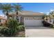 Home featuring a two-car garage with a well-maintained driveway and tropical landscaping at 7608 Teal Trce, Bradenton, FL 34203