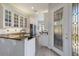 Charming kitchen with granite countertops, white cabinetry, and a stylish glass front door at 7608 Teal Trce, Bradenton, FL 34203