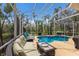 Screened-in pool area with cozy furniture and lush tropical surroundings at 7608 Teal Trce, Bradenton, FL 34203