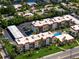 Aerial view of a condo with a pool, parking, and lush landscaping at 901 Beach Rd # 402, Sarasota, FL 34242