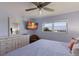 Bedroom features bright beach views, a ceiling fan, and dresser at 901 Beach Rd # 402, Sarasota, FL 34242