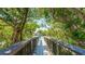 Picturesque wooden boardwalk winds through lush greenery, leading to tranquil waterfront views at 9200 Midnight Pass Rd # 20, Sarasota, FL 34242