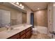 Bathroom featuring double sink vanity, tiled walls, and a shower-tub combo with a blue curtain at 10811 High Noon Trl, Parrish, FL 34219