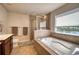 Bathroom featuring a shower, tub and a beautiful window view at 10811 High Noon Trl, Parrish, FL 34219