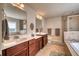 Bathroom featuring double vanity sinks, a separate shower and a soaking tub at 10811 High Noon Trl, Parrish, FL 34219