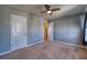 Neutral-toned bedroom with carpet flooring, ceiling fan, and a view into the hallway at 10811 High Noon Trl, Parrish, FL 34219