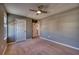 Neutral-toned bedroom with carpet flooring, ceiling fan, and a view into the hallway at 10811 High Noon Trl, Parrish, FL 34219