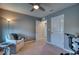 Bedroom setup with an armchair, desk, exercise bike, and carpet flooring, all naturally lit at 10811 High Noon Trl, Parrish, FL 34219