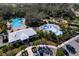 Aerial view of community pool, playground, splash pad, and clubhouse surrounded by lush landscaping at 10811 High Noon Trl, Parrish, FL 34219