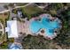 Aerial view of the community pool with lounge chairs, landscaping and amenity center at 10811 High Noon Trl, Parrish, FL 34219