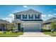 Two-story home featuring gray siding, blue shutters, and a well-manicured front yard at 10811 High Noon Trl, Parrish, FL 34219