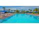 Large swimming pool with lounge chairs and blue umbrellas at 1105 Gulf Of Mexico Dr # 603, Longboat Key, FL 34228