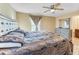 A bedroom features neutral walls, a ceiling fan, and a window with curtains at 1122 42Nd E Ter, Bradenton, FL 34208