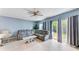 Comfortable living room area with a gray sofa, sliding glass doors, and natural light at 1122 42Nd E Ter, Bradenton, FL 34208