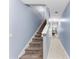 Carpeted staircase leading to the upper level, adjacent to a hallway with tile flooring at 1122 42Nd E Ter, Bradenton, FL 34208