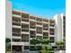 Exterior of the condominium building with a manicured landscape and mature trees at 1145 Gulf Of Mexico Dr # 305, Longboat Key, FL 34228