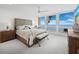 Bright main bedroom featuring ocean views from the large picture windows and ceiling fan at 1145 Gulf Of Mexico Dr # 305, Longboat Key, FL 34228