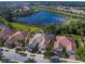 An aerial view showcasing the property's location near a lake, landscaping, and tiled roof at 11629 Garessio Ln, Sarasota, FL 34238