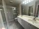 Bathroom features double sinks, walk-in shower, large mirror, and tile flooring at 11629 Garessio Ln, Sarasota, FL 34238