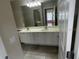 Bathroom features double sinks, large mirror, tile flooring, and white cabinets at 11629 Garessio Ln, Sarasota, FL 34238