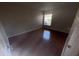 Simple bedroom with gleaming hardwood floors and a window at 11629 Garessio Ln, Sarasota, FL 34238