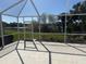 A view of the screened patio with tile floor overlooking the backyard and waterway at 11629 Garessio Ln, Sarasota, FL 34238