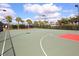 Community tennis court surrounded by palm trees and lush landscaping offers a great recreational space at 11629 Garessio Ln, Sarasota, FL 34238