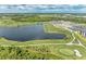 Scenic aerial view of a golf course with a large lake, lush greenery, and distant residential development at 12510 Ghiberti Cir # 102, Venice, FL 34293