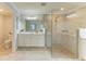 Bright bathroom featuring a glass-enclosed shower, double sink vanity, and neutral tile at 12510 Ghiberti Cir # 102, Venice, FL 34293