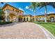 Welcoming entrance to a community with brick paved drive and Mediterranean-style architecture at 12510 Ghiberti Cir # 102, Venice, FL 34293