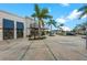 Commercial building exterior with palm trees, sidewalk, and blue awnings, creating a welcoming atmosphere at 12510 Ghiberti Cir # 102, Venice, FL 34293