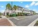 Modern building with palm trees, manicured landscaping and street parking under bright sky at 12510 Ghiberti Cir # 102, Venice, FL 34293