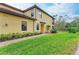 Exterior of a tan home with a manicured lawn and trimmed hedges along the side at 12510 Ghiberti Cir # 102, Venice, FL 34293