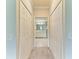 Hallway view of the bathroom with white cabinets and flooring at 12510 Ghiberti Cir # 102, Venice, FL 34293