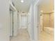 Hallway view leading to bathroom with tub and tile walls at 12510 Ghiberti Cir # 102, Venice, FL 34293