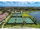 Aerial view of community tennis courts next to a lake, offering a recreational amenity for residents at 12510 Ghiberti Cir # 102, Venice, FL 34293