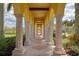 Covered walkway with stone columns provides a shaded path for walking and enjoying the community views at 12510 Ghiberti Cir # 102, Venice, FL 34293