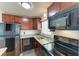 Cozy kitchen featuring granite counters, wood cabinets, and modern black appliances at 1517 Pleasant Rd # A22, Bradenton, FL 34207