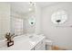 Bright bathroom featuring double sinks, decorative window, and a shower-tub combo with striped curtain at 1555 Napoli W Dr, Sarasota, FL 34232