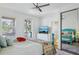 Bedroom with a bright blue four-poster bed, television, and a large window showcasing natural light at 1555 Napoli W Dr, Sarasota, FL 34232