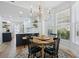 Bright dining area features a round table, chandelier, and large windows at 1555 Napoli W Dr, Sarasota, FL 34232