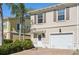 Charming townhome with tan stucco exterior, brick drive, attached garage and well-maintained landscaping at 1555 Napoli W Dr, Sarasota, FL 34232